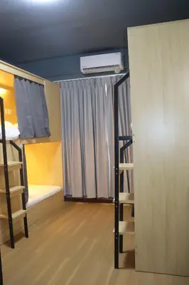 a room with two bunk beds and a closet at The Moment Hostel in Bangkok