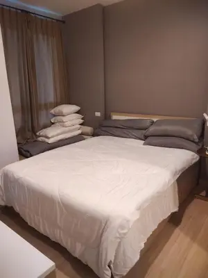 a large white bed in a room with a window at Appartement douillet pool fitness in Bangkok
