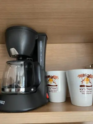 a black coffee maker sitting next to two coffee cups at Appartement douillet pool fitness in Bangkok