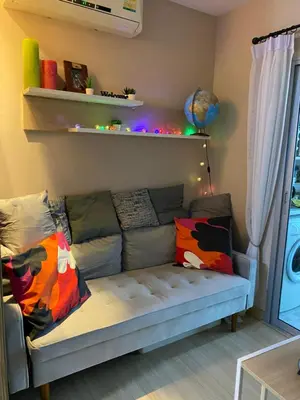a living room with a couch with colorful pillows at Appartement douillet pool fitness in Bangkok