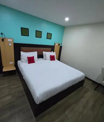 a bedroom with a large white bed with red pillows at Residency Hotel Bangkok in Bangkok