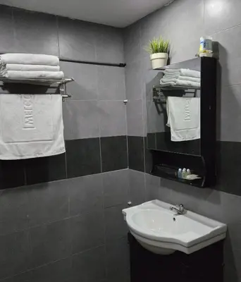 a bathroom with a sink and white towels at Residency Hotel Bangkok in Bangkok