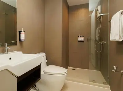 a bathroom with a toilet and a sink and a shower at Mövenpick Residence Ekkamai in Sathani Khlong Tan