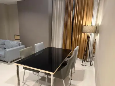 a dining room with a black table and chairs at Mövenpick Residence Ekkamai in Sathani Khlong Tan