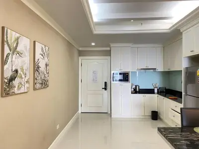 a kitchen with white cabinets and a white refrigerator at BangrakHomey - Cozy private Apartment in State tower bangkok in Bangkok