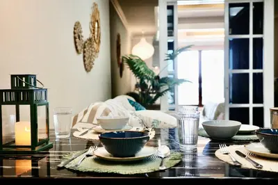 a dining room table with bowls and plates on it at BangrakHomey - Cozy private Apartment in State tower bangkok in Bangkok