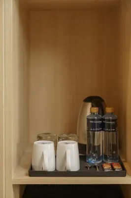 a shelf with cups and a tea kettle on it at iCheck inn Thapra in Bangkok
