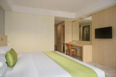 a bedroom with a large bed with a television on a wall at iCheck inn Thapra in Bangkok