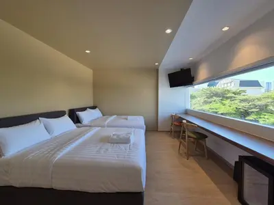 a bedroom with two beds and a large window at The Publyc Hotel in Bangna