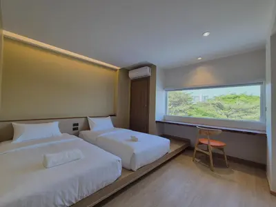 a hotel room with two beds and a window at The Publyc Hotel in Bangna