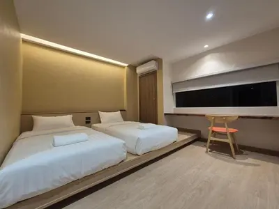 a bedroom with two beds and a flat screen tv at The Publyc Hotel in Bangna