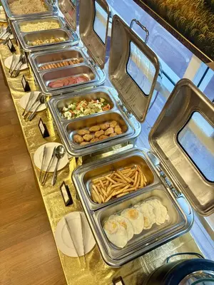 a buffet with trays of food on a table at Klassique Sukhumvit Hotel in Bangkok