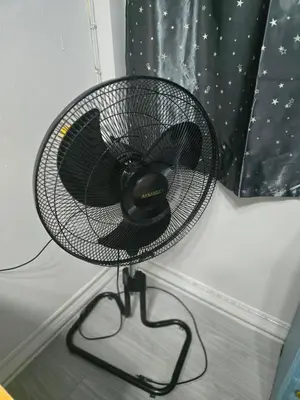 a black fan sitting on a stand in a room at 104 Peaceful and Cosy apartment near BTS with free WiFi in Bangkok