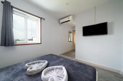 a bedroom with a bed and a tv and a window at OH Hostels - Bangkok in Bangkok