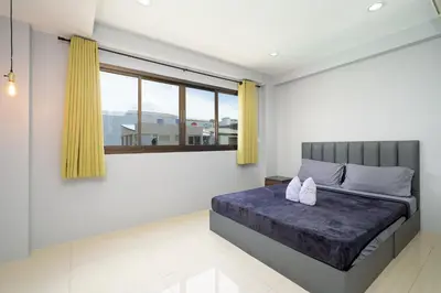 a bedroom with a bed and a large window at OH Hostels - Bangkok in Bangkok