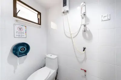 a white bathroom with a shower and a toilet at OH Hostels - Bangkok in Bangkok