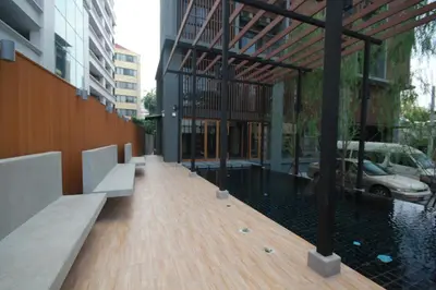 a building with a wooden walkway in a city at Sereine Sukhumvit 39 in Bangkok
