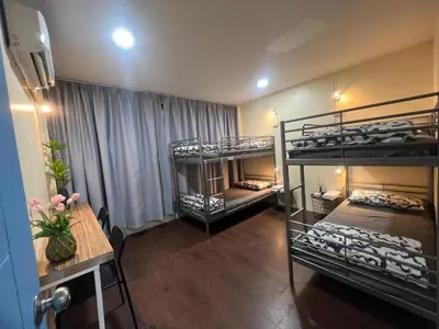 a room with two bunk beds and a table and a tableablishthritisthritisthritis at \u5e0c\u671b\u66f4\u597d\u6c11\u5bbf in Bang Rak