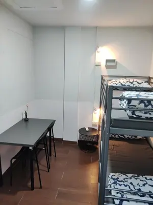 a room with two bunk beds and a table at \u5e0c\u671b\u66f4\u597d\u6c11\u5bbf in Bang Rak