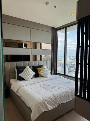 a bedroom with a large bed with a large window at The Esse Asoke in Bangkok