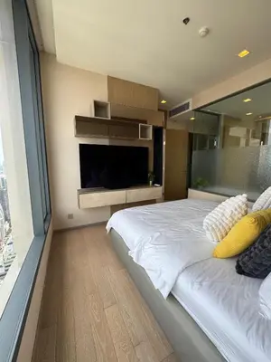 a bedroom with a large bed with a tv on the wall at The Esse Asoke in Bangkok