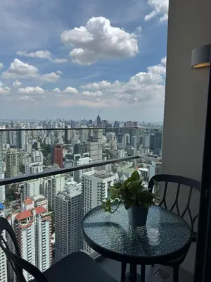 a table with a potted plant on top of a window at The Esse Asoke in Bangkok