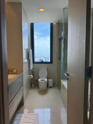 a bathroom with a toilet and a window at The Esse Asoke in Bangkok