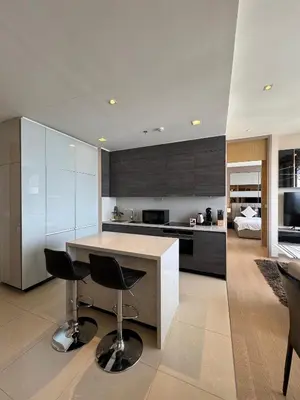 a kitchen with a counter and chairs in a room at The Esse Asoke in Bangkok