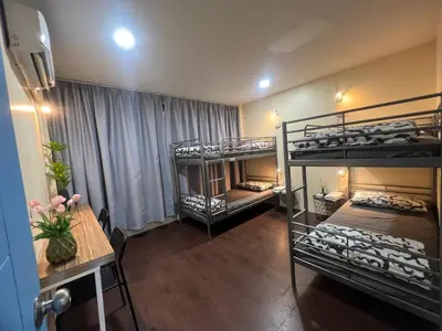 a room with three bunk beds and a table and a tableablishthritisthritisthritis at Youjia Youth Hostel in Bang Rak