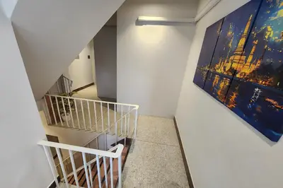 a staircase in a building with a painting on the wall at Shade House Bangkok Oldtown in Bangkok