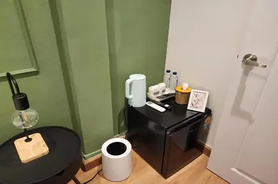 a small bathroom with a black table and a green wall at Shade House Bangkok Oldtown in Bangkok