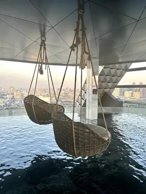 two baskets hanging from a bridge over water at Condo Luxe Siam Pool 360 Near BTS Shopping in Bangkok