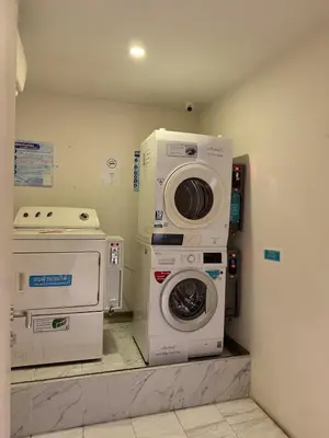 a laundry room with a washing machine and a washer at Condo Luxe Siam Pool 360 Near BTS Shopping in Bangkok