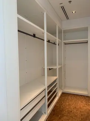 a white walk in closet with white shelves at Ritz Carlton Residences in Bangkok