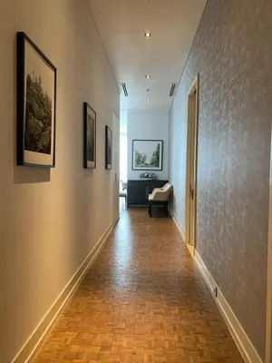 an empty hallway with a couch and paintings on the wall at Ritz Carlton Residences in Bangkok