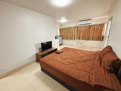 a bedroom with a bed and a television in it at Impact - Don Mueng Condo C5 in Thung Si Kan