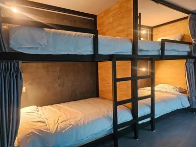 a bunk bed room with two bunk beds in it at บ้านรังนก The Bird Nest Homestay & Coffeeshop in Samut Prakan