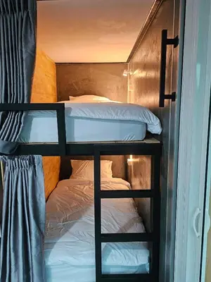 a couple of bunk beds in a room at บ้านรังนก The Bird Nest Homestay & Coffeeshop in Samut Prakan