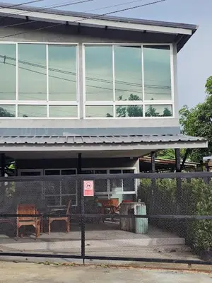 a building with a fence in front of it at บ้านรังนก The Bird Nest Homestay & Coffeeshop in Samut Prakan
