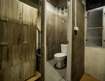 a bathroom with a toilet and wooden walls at Mind Day Hostel Khaosan in Bangkok