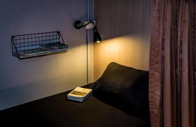 a book sitting on a couch next to a lamp at Mind Day Hostel Khaosan in Bangkok