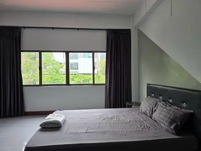a bedroom with a bed and a large window at SRINN House, Bangkok in Bangkok