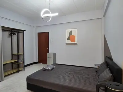 a bedroom with a bed and a white wall at SRINN House, Bangkok in Bangkok