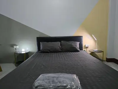 a large bed in a room with two tables at SRINN House, Bangkok in Bangkok