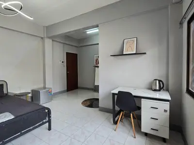 a bedroom with a bed and a desk with a chair at SRINN House, Bangkok in Bangkok