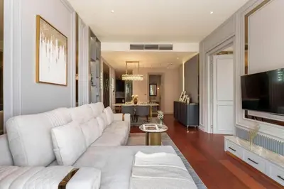 a living room with a white couch and a tv at Prime Area Super Cozy Luxury 2 bedroom Asoke BTS in Bangkok
