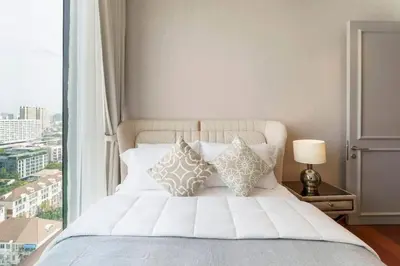 a bedroom with a white bed with a window at Prime Area Super Cozy Luxury 2 bedroom Asoke BTS in Bangkok