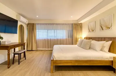 a bedroom with a bed and a desk and a table at AB House in Bangkok