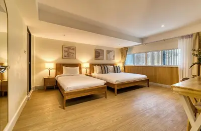 a hotel room with two beds and a window at AB House in Bangkok
