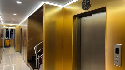a elevator in a building with yellow walls at Golden Mango home hotel \u91d1\u8292\u679c\u4e4b\u5bb6\u9152\u5e97 in Bangkok